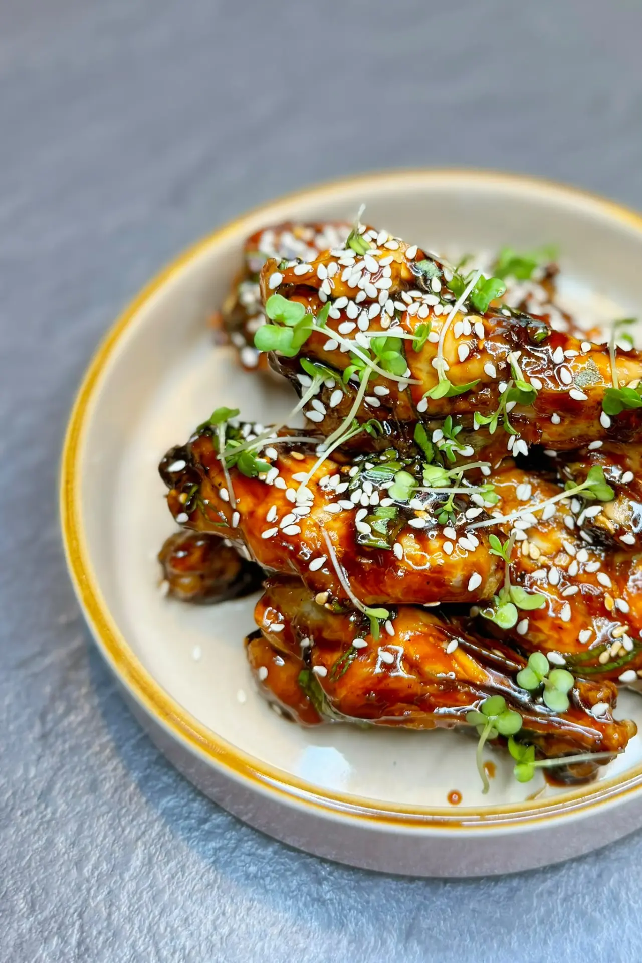 Sticky glazed chicken wings with sesame and micro herbs