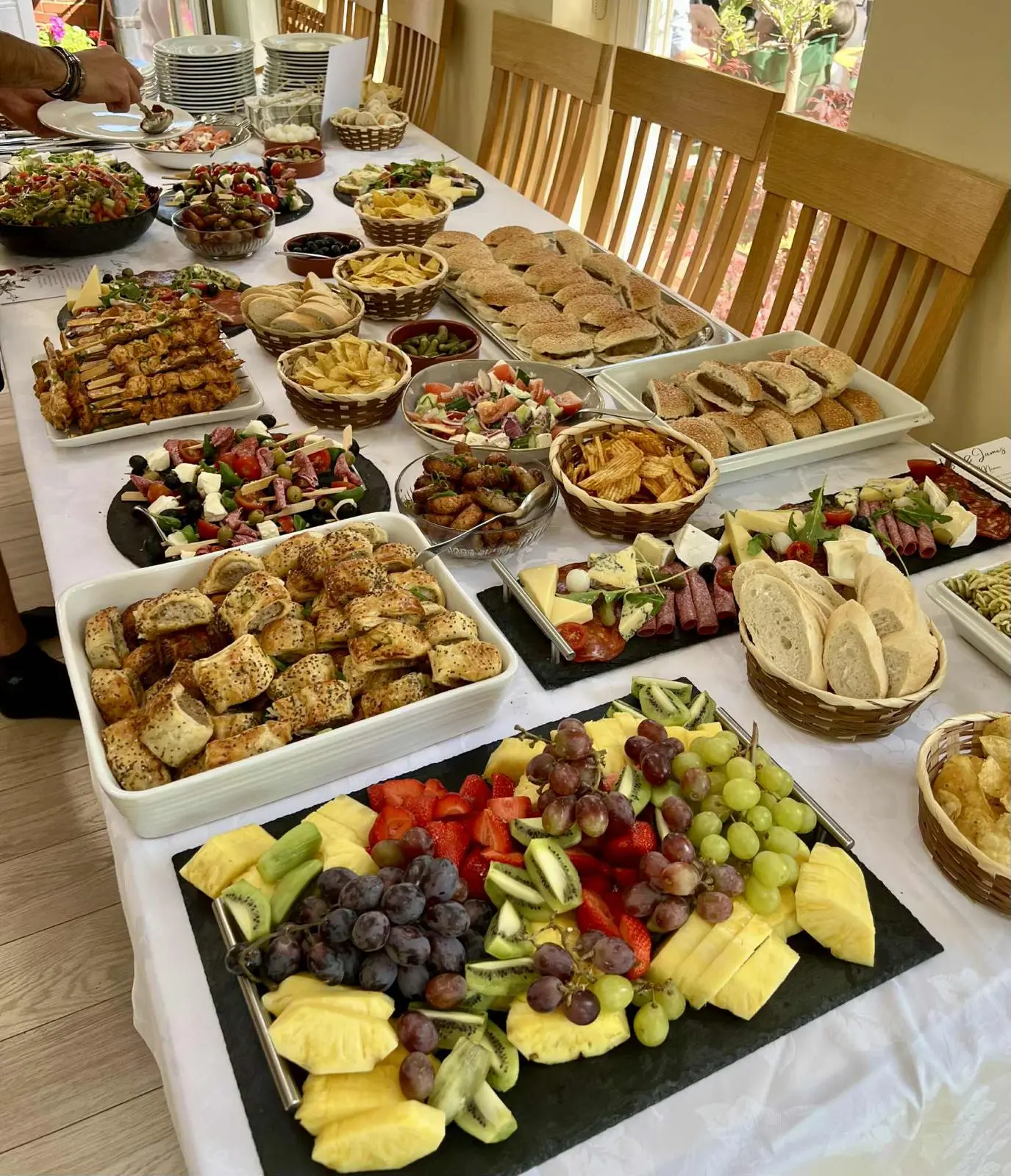 Buffet spread with sausage rolls, skewers and fresh fruit