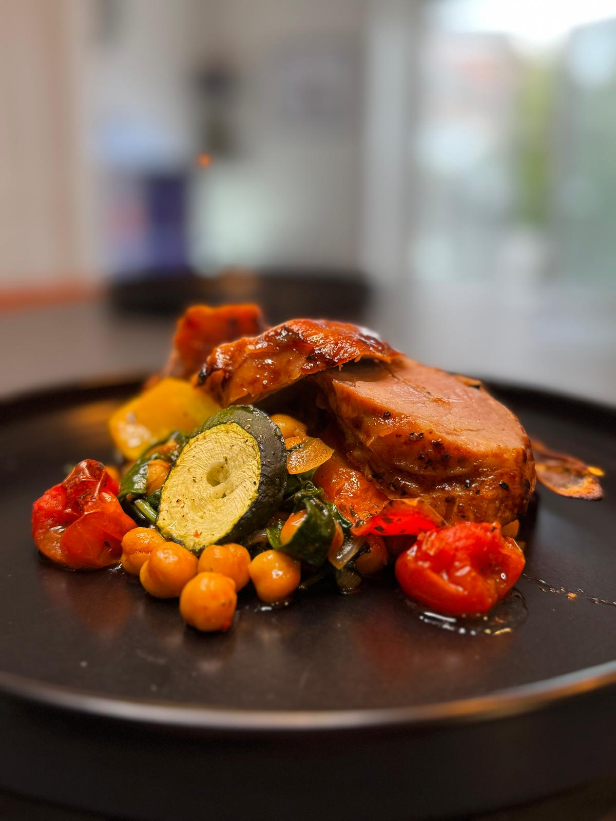 Glazed pork loin with chickpeas, courgette and roast peppers