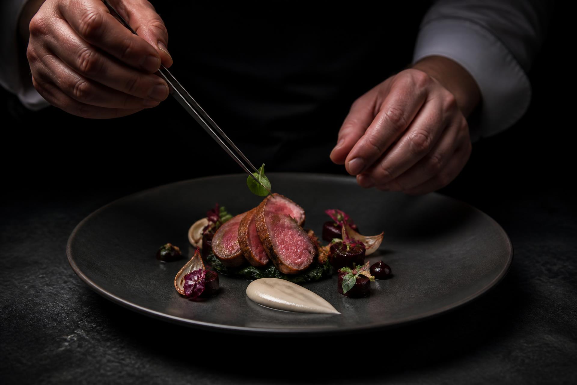 Fine dining dish being finished by a private chef